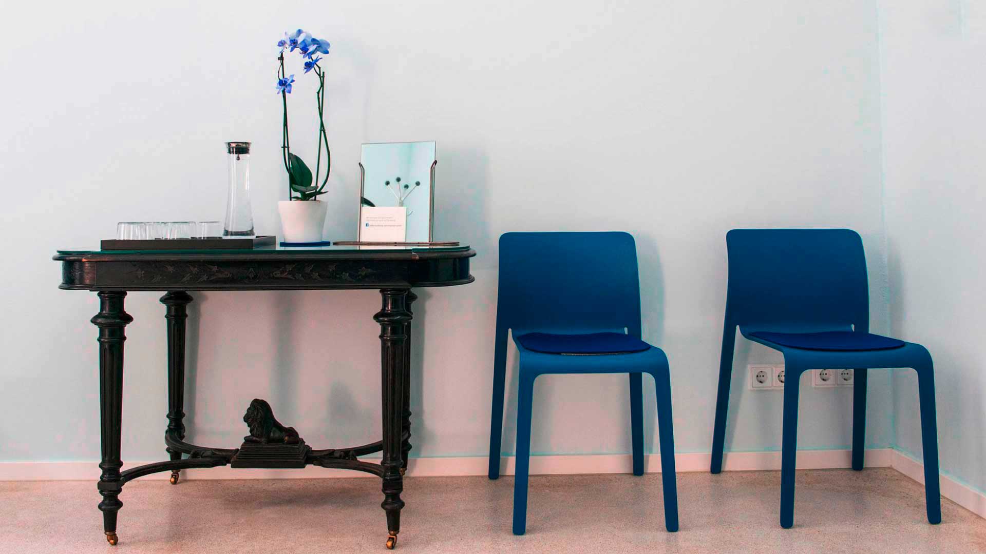 Dr. Peter Merkle, Wartezimmer mit blauen Stühlen und Tisch mit Kunstbüchern 